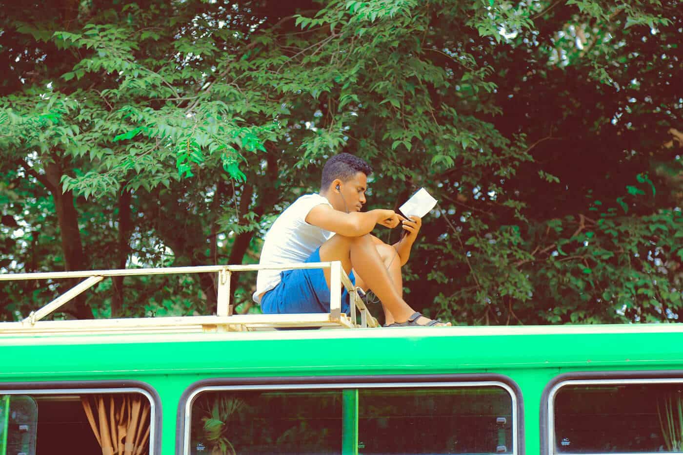 man reading on top of a bus