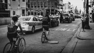 Cyclists riding past cars on Chicago street