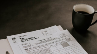 Tax withholding form on table next to cup of coffee